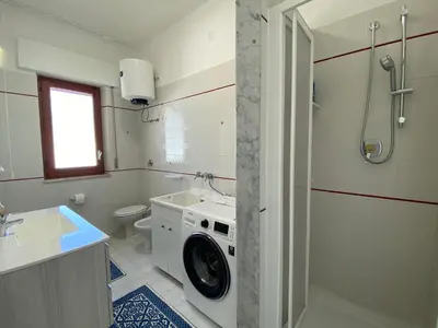 a bathroom with a washing machine in a sink at Brezza Marina Apartment, 50 mt dalla spiaggia in Alcamo