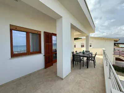 a balcony of a house with a table and chairs at Brezza Marina Apartment, 50 mt dalla spiaggia in Alcamo