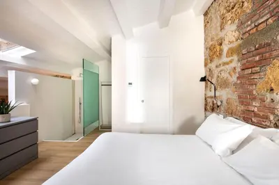 a bedroom with a brick wall and a white bed at Casa Design tra le Mura by Wonderful Italy in Palermo