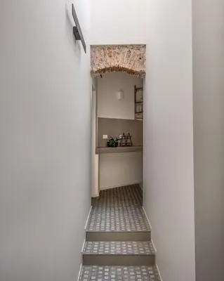 a hallway with a stairway leading into a room with a counter at Casa Design tra le Mura by Wonderful Italy in Palermo