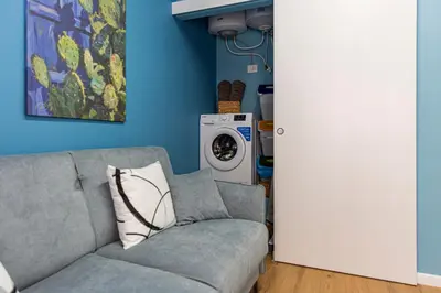 a living room with a couch and a washing machine at Le Carte in Castellammare del Golfo