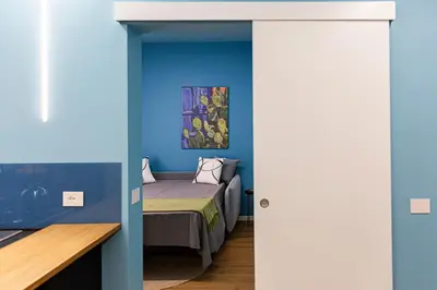 a bedroom with a bed and a blue wall at Le Carte in Castellammare del Golfo