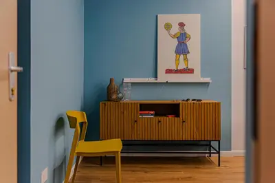 a room with a wooden cabinet and a yellow chair at Le Carte in Castellammare del Golfo