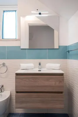 a bathroom with a sink and a mirror at GuestHost - La Giara - Villa with Swimming Pool and Parking in Castellammare del Golfo