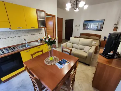 a kitchen and living room with a table and a couch at Politeama guest house Palermo Pomelia in Palermo