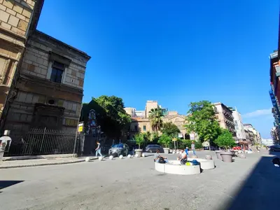 a group of people sitting in white barrels on a street at Politeama guest house Palermo Pomelia in Palermo