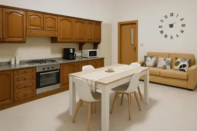 a kitchen with a table and chairs and a couch at Appartamento Matteo in Trappeto