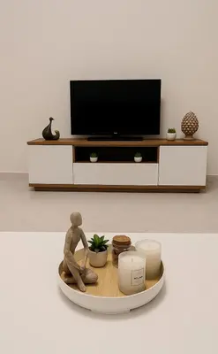 a living room with a tv and a person sitting on a table at Appartamento Matteo in Trappeto
