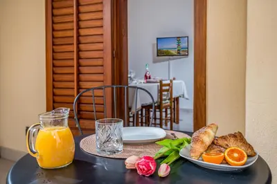 a table with a plate of food and a glass of orange juice at Casa Dolce Casa in Castellammare del Golfo