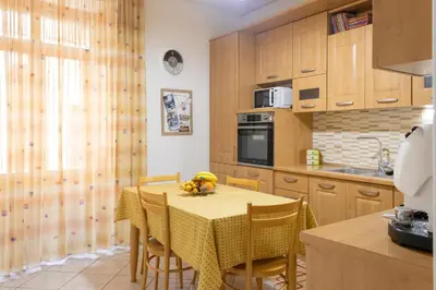 a kitchen with a table and chairs with bananas on it at Casa Dolce Casa in Castellammare del Golfo