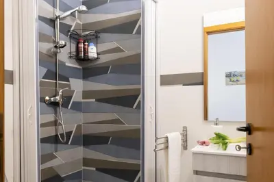 a bathroom with a blue and gray striped wall at Casa Dolce Casa in Castellammare del Golfo