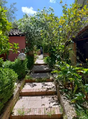 a garden with a stone path with trees and bushes at Home SG jato in San Giuseppe Jato