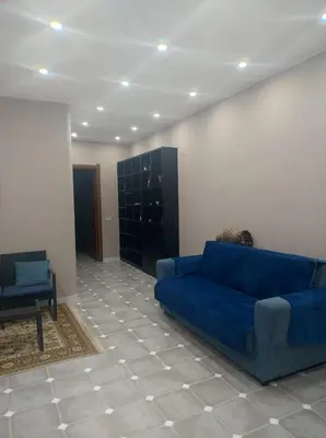 a living room with a blue couch and a chair at Home SG jato in San Giuseppe Jato