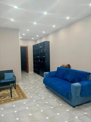 a living room with a blue couch and a chair at Home SG jato in San Giuseppe Jato