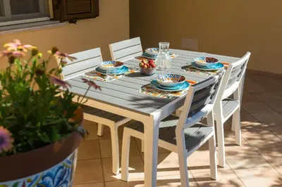 a blue table with chairs and plates on it at Isola Suite in Isola delle Femmine
