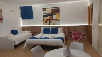 a room with two beds and a table and chairs at Isola Suite in Isola delle Femmine