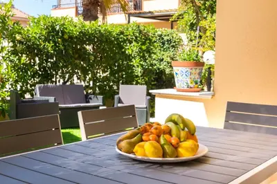 a plate of fruit on a table on a patio at Isola Suite in Isola delle Femmine