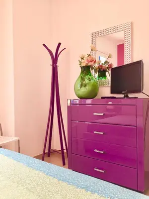 a purple dresser with a tv and a mirror at Villa La Palmetta a San Vito lo capo in San Vito lo Capo