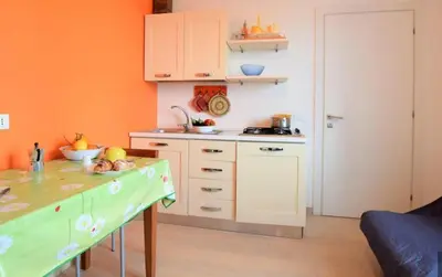 a kitchen with orange walls and a counter top at Villa La Palmetta a San Vito lo capo in San Vito lo Capo