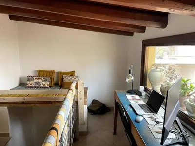 a bedroom with a bed and a desk with a laptop at Cozy 2BR in the heart of Palermo in Palermo