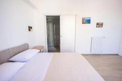 a bedroom with a large white bed with white pillows at Mangano Suites in Palermo