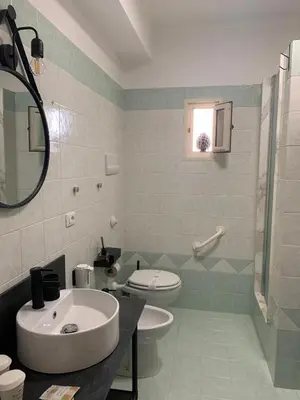 a bathroom with a sink and a toilet and a mirror at A CASA DI GRACE in Palermo
