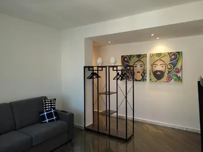 a living room with a couch and paintings on the wall at A CASA DI GRACE in Palermo
