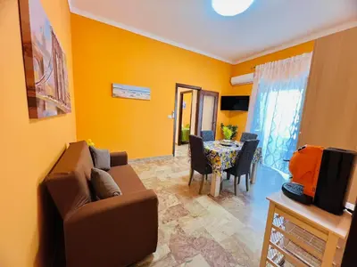 a living room with a couch and a table at Orange House in Isola delle Femmine