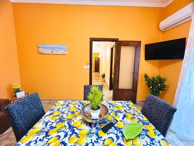 a dining room with a table and chairs with a table at Orange House in Isola delle Femmine
