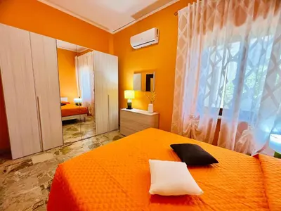 a bedroom with an orange bed and a window at Orange House in Isola delle Femmine