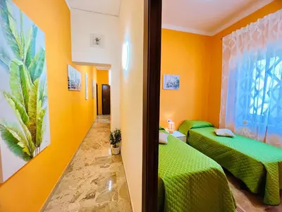 two beds in a room with yellow walls at Orange House in Isola delle Femmine