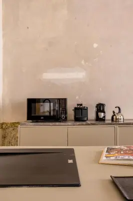 a laptop sitting on a counter with a microwave at Palazzo Sant'Isidoro by DomuSicily in Palermo
