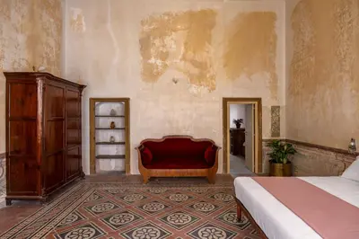 a bedroom with a bed and a red couch at Palazzo Sant'Isidoro by DomuSicily in Palermo