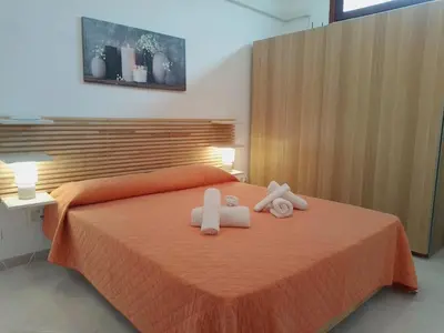 a bedroom with a bed with two towels on it at Sanvitotour - Appartamento Amaca in San Vito lo Capo