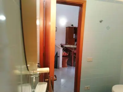 a bathroom with a toilet and a sink and a mirror at Sanvitotour - Appartamento Amaca in San Vito lo Capo