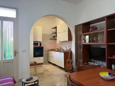 a kitchen with an archway and a table with a guitar at Casa Finuzza in San Vito lo Capo