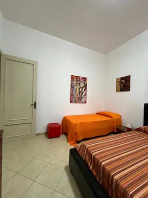 a hotel room with two beds and a door at Casa Finuzza in San Vito lo Capo