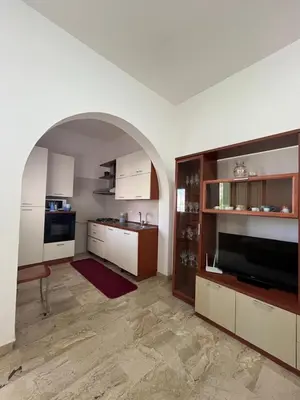 a kitchen with white cabinets and an archway at Casa Finuzza in San Vito lo Capo