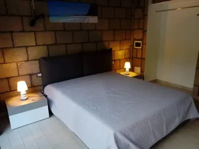 a bedroom with a white bed and two lamps on tables at Loft Mondello Beach in Palermo