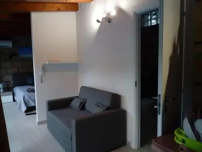 a living room with a couch and a door at Loft Mondello Beach in Palermo