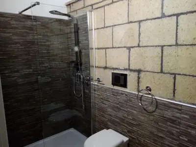 a bathroom with a glass shower with a toilet at Loft Mondello Beach in Palermo