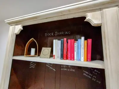 a shelf full of books on a wall at Domus Vetriera in Palermo