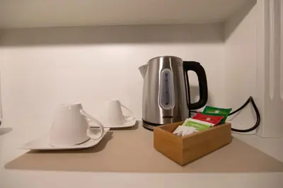 a counter top with a tea kettle and cups and a box at Villareale47 Luxury Suites & Rooms in Palermo