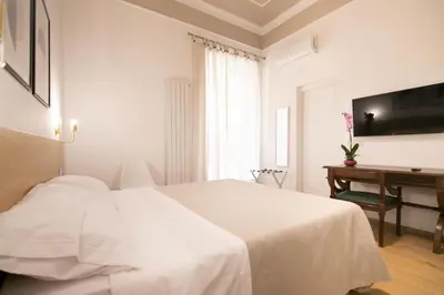 a white bedroom with a bed and a desk at Villareale47 Luxury Suites & Rooms in Palermo
