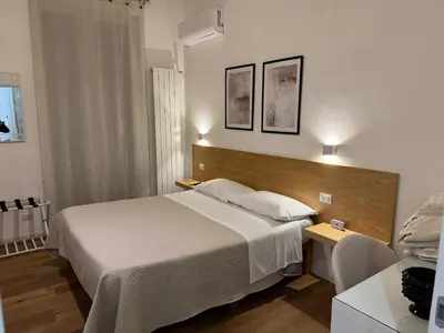 a hotel room with a bed and a desk and a bed sidx sidx sidx sidx at Villareale47 Luxury Suites & Rooms in Palermo