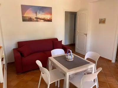 a living room with a red couch and a table and chairs at PANORAMIC VIEW - Sabrina's house in Altavilla Milicia