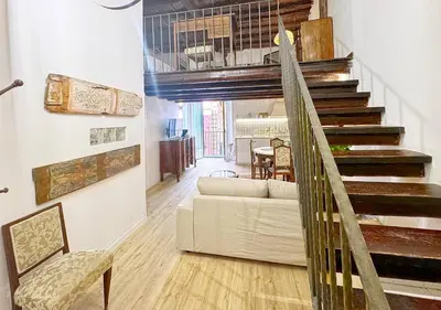 a living room with a white couch and stairs at Solemar Sicilia - Casa Enrica in Palermo
