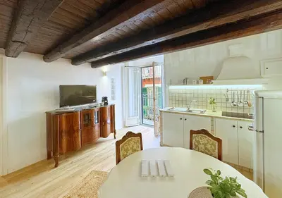 a kitchen with a white table and a table and chairs at Solemar Sicilia - Casa Enrica in Palermo
