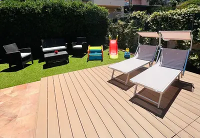 a patio with two hammocks and chairs on the grass at Chalet Seaview by AR Group Hotels in Isola delle Femmine