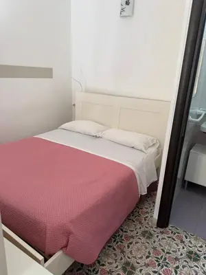 a bedroom with a bed with a pink blanket at Casa Fugardi in Castellammare del Golfo